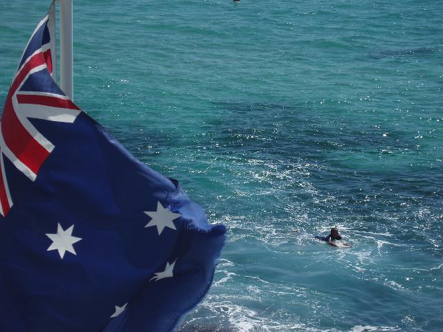 the australian flag and blue cyan waters off the new south wales coast