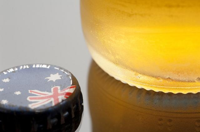 a bottle of beer and a bottle cap with the australian flag on it