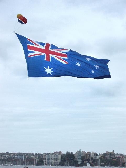 a massive australian flag being towed by a boat and parascending kite