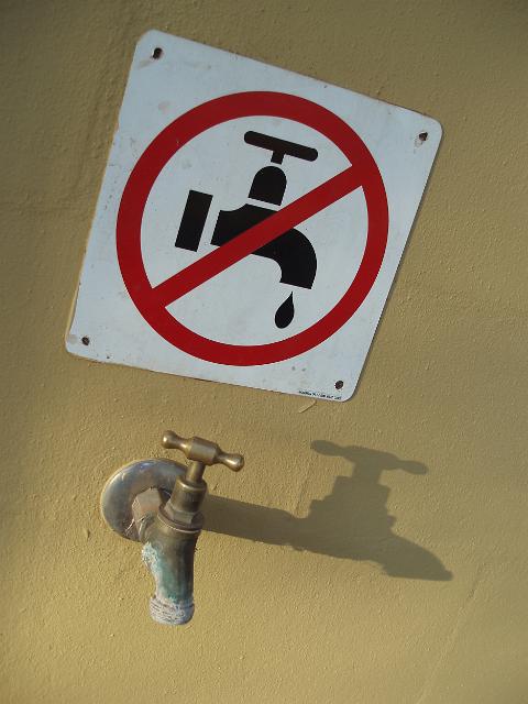 a save water sign - urging visitors not to leave taps dripping