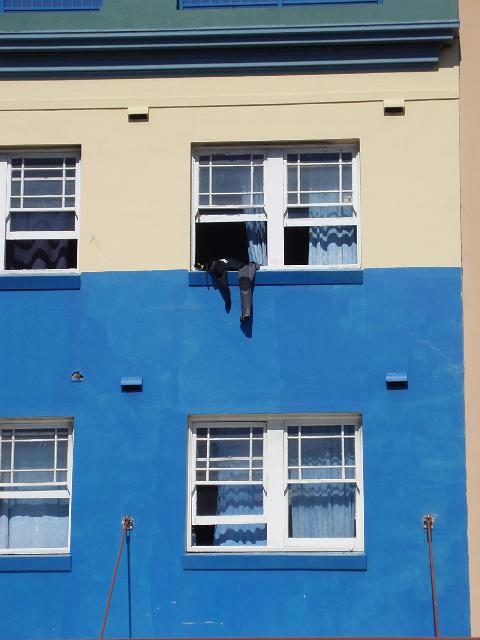 a wet suit hanging from a hostel window to dry