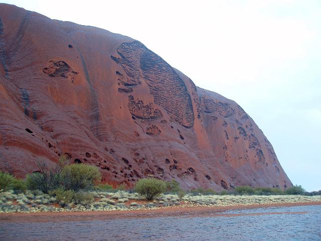 a view of uluru after a passing shower, an unusual sight in the red centre