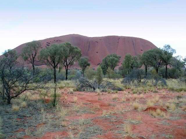 distinctive red rockface of uluru and red soil of australias red centre