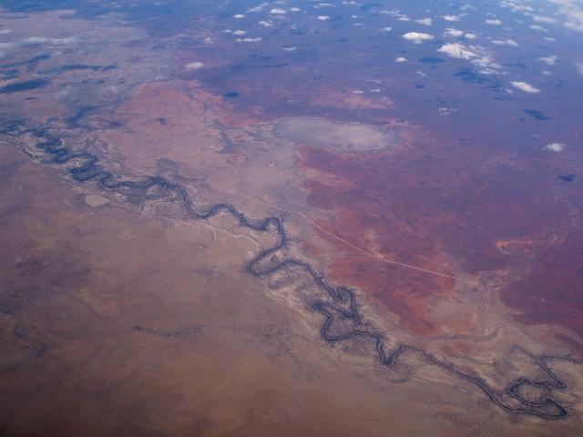 a dry riverbed snaking its way through the queensland outback