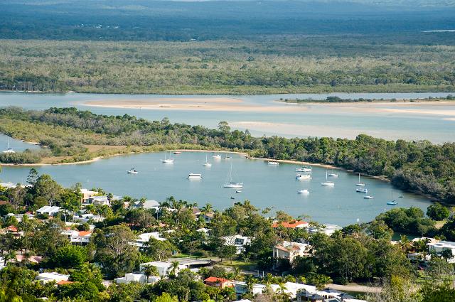 Aerial view of the estuary and the Noosa River basins which provide a sheltered mooring for small pleasure boats with houses set amongst trees and lush tropical vegetation