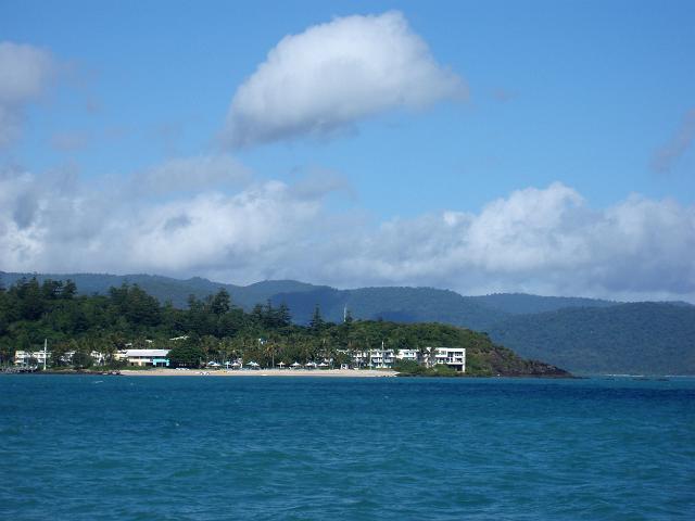 a daytime view of daydream island with the australian mainland in the rear