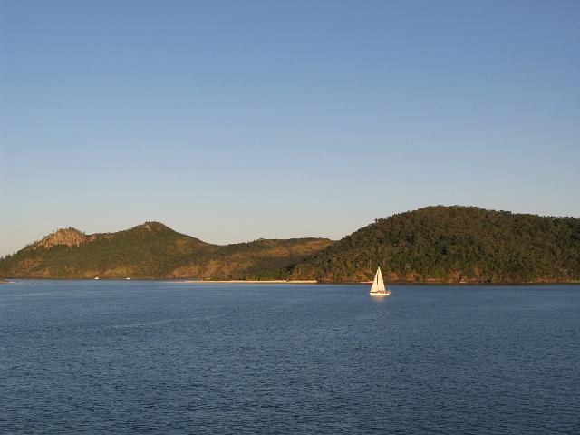a single sailing boat navigating its way around the whitsunday isalnds, queensland