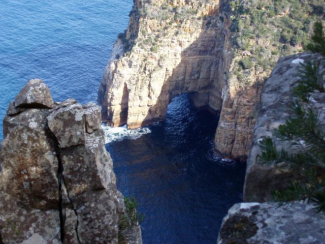 a rock arch erdoded by water into the cliffs of the tasman peninsula between cape pillar and cape hauy