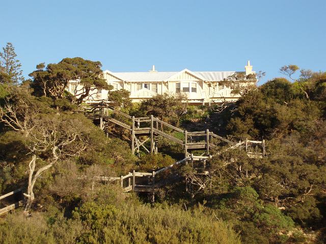 a house nestled in sand dunes with steps infront