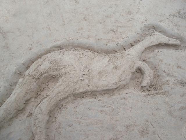 a kangaroo shaped sculpture in the sand on a beach