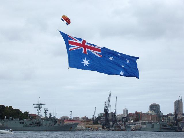 a large australian flag bring flown above garden island dock yard sydney