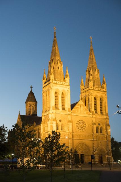 The Gothic facade of St Peters Cathedral, Adelaide, South Australia illuminated at night under a twilight sky