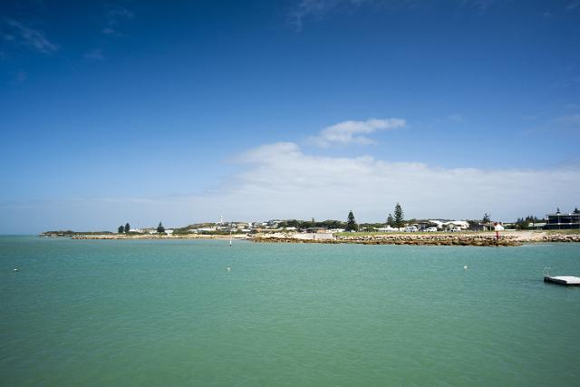 View from a jetty across a calm sea of the coastline of Rivoli Bay and beachfront properties in Beachport, Australia